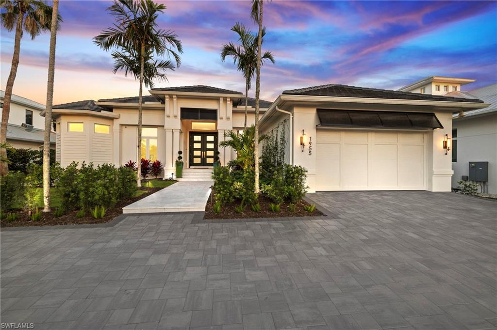 1955 Tarpon Road Naples, FL 34102 - Photo 2 of 48 Prairie-style home featuring french doors, stucco siding, decorative driveway, and an attached garage