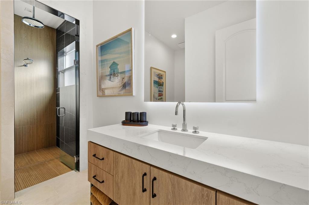 1955 Tarpon Road Naples, FL 34102 - Photo 22 of 48 Bathroom featuring a stall shower, vanity, and light tile patterned floors