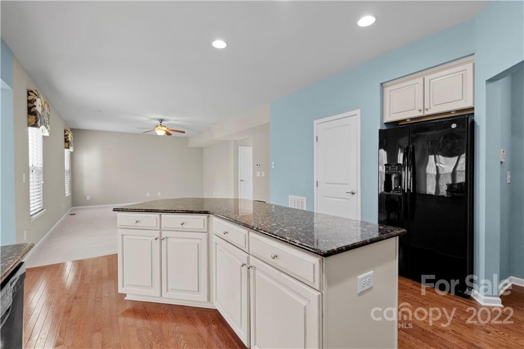7720 East Berkeley Road Denver, NC 28037 - Photo 11 of 40 a kitchen with granite countertop a sink and dishwasher with white cabinets
