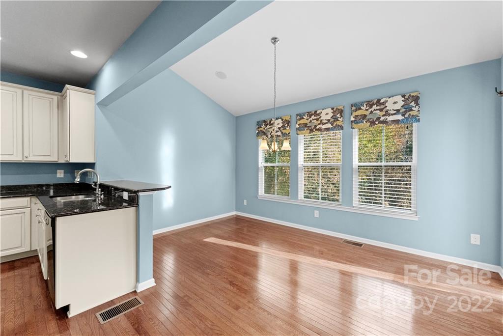 7720 East Berkeley Road Denver, NC 28037 - Photo 13 of 40 a view of a kitchen with a stove wooden floor and a window