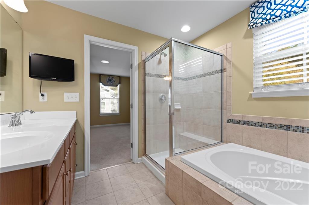 7720 East Berkeley Road Denver, NC 28037 - Photo 27 of 40 a spacious bathroom with a granite countertop sink mirror and bathtub