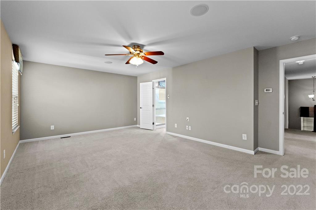 7720 East Berkeley Road Denver, NC 28037 - Photo 30 of 40 an empty room with windows and chandelier fan