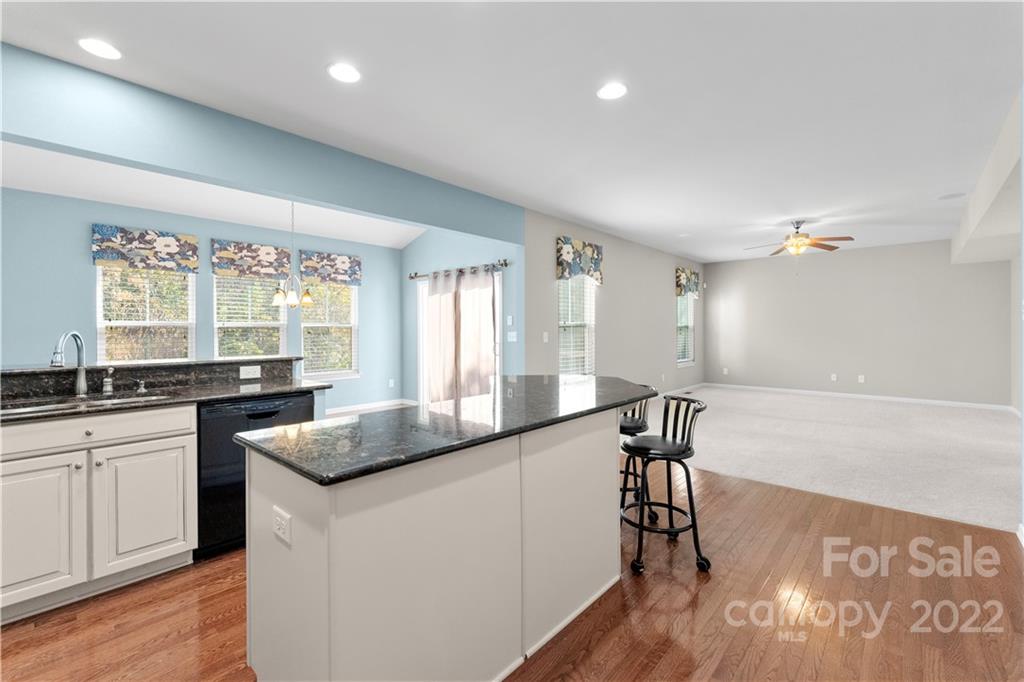 7720 East Berkeley Road Denver, NC 28037 - Photo 10 of 40 a kitchen with stainless steel appliances granite countertop sink stove and wooden floor