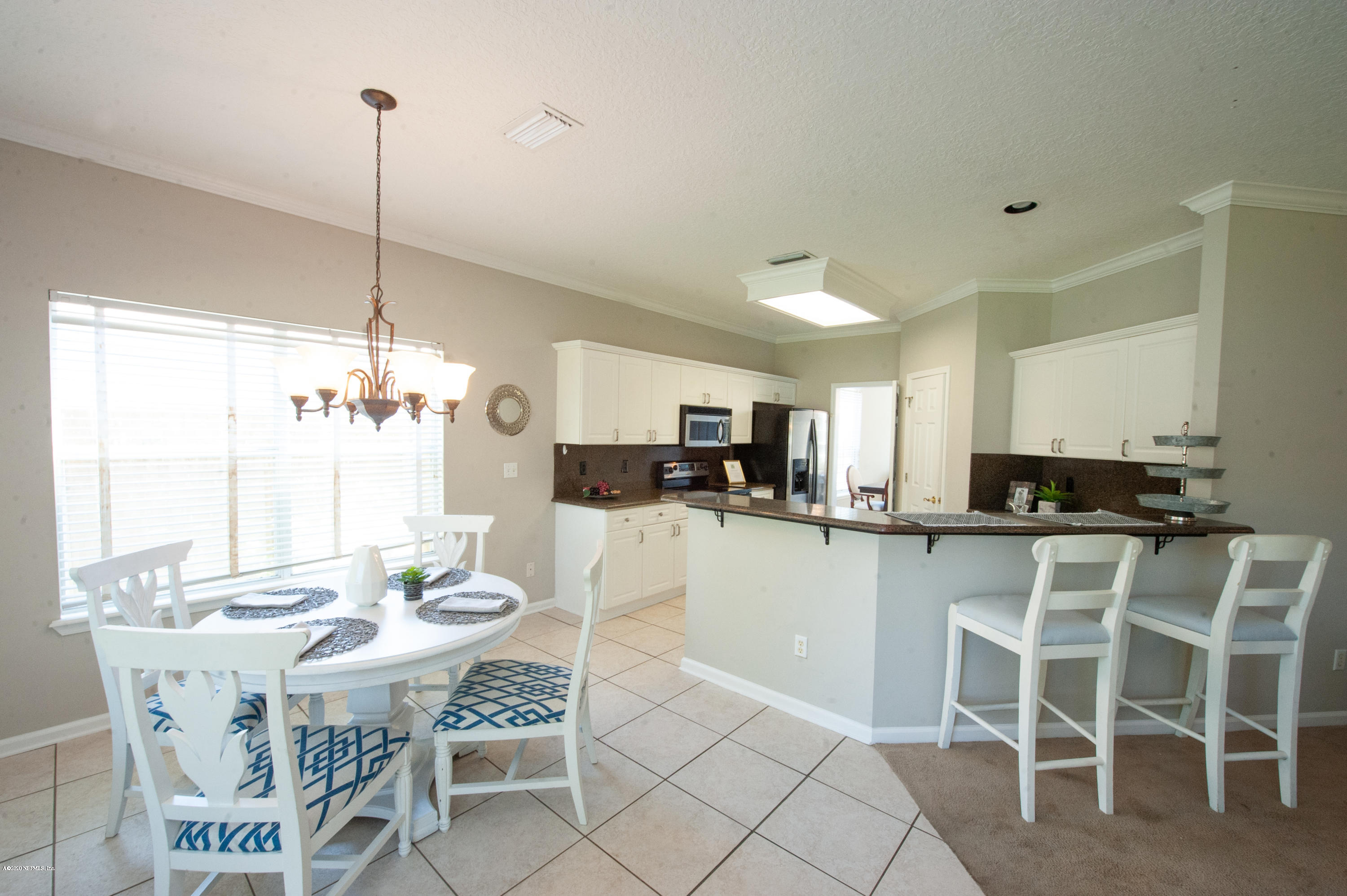 446 Big Tree Road Ponte Vedra Beach, FL 32082 - Photo 9 of 21 a kitchen with a dining table chairs and white cabinets