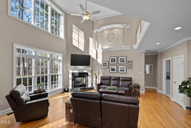 a kitchen with stainless steel appliances kitchen island granite countertop a refrigerator a oven and a wooden floors