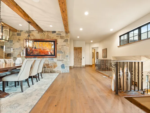 a view of a hallway with wooden floor and a living room