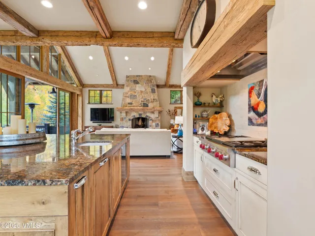a room with stainless steel appliances kitchen island granite countertop a stove and a sink