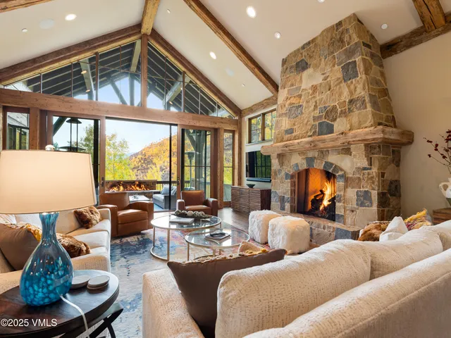 a living room with fireplace furniture and a large window