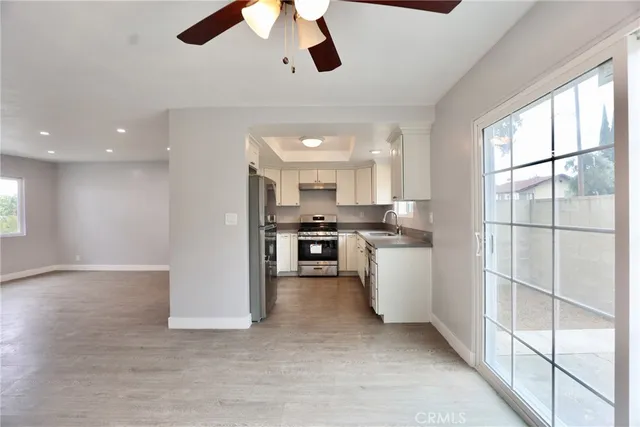 a kitchen with stainless steel appliances kitchen island a large counter space a sink and a window