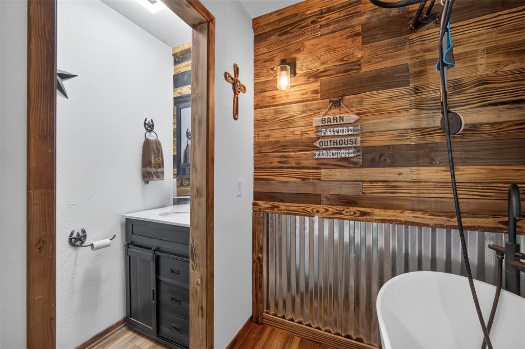 10964 River Ranch Road Kemp, TX 75143 - Photo 28 of 40 Wood-finish plank accent wall, corrugated metal wainscoting, and a freestanding soaking tub