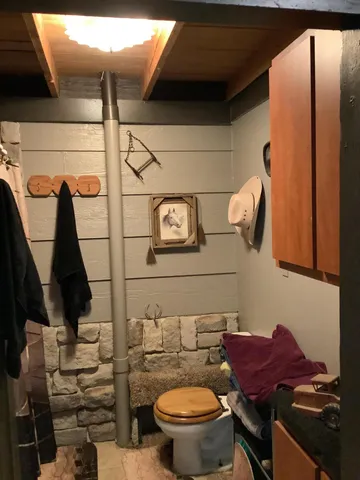 a bathroom with a toilet and a mirror