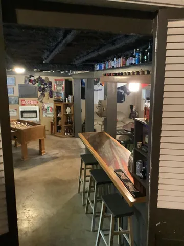 a living room with furniture a flat screen tv and gym equipment