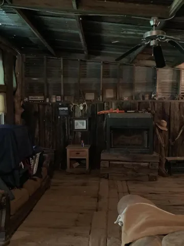 a view of backyard with table and chairs and potted plants and large trees