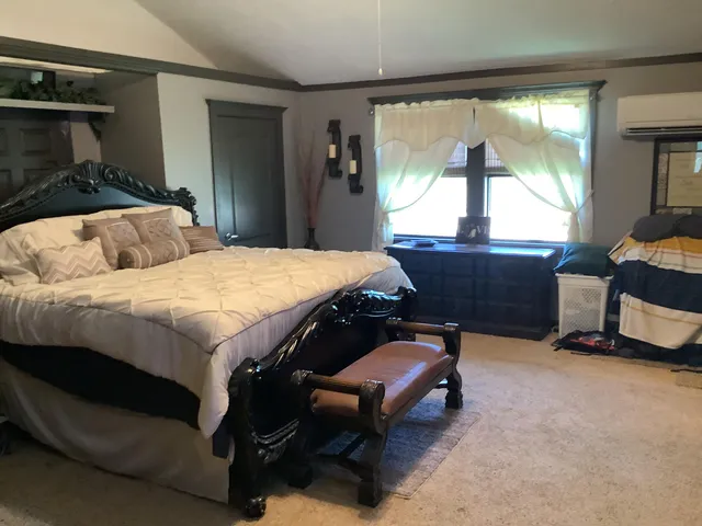 a bedroom with a bed and a larger window