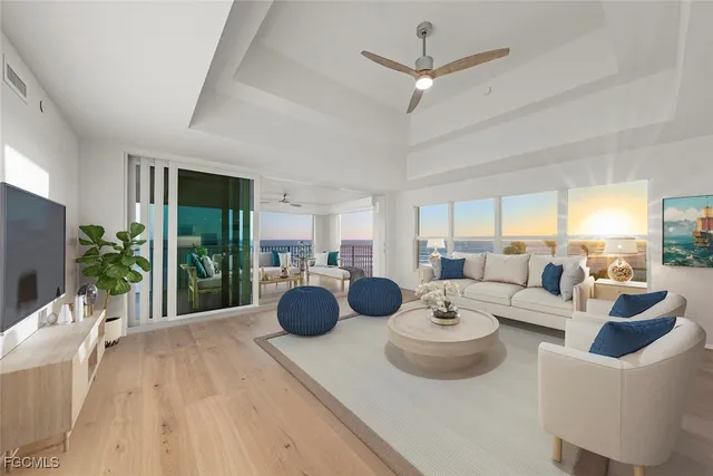 a living room with furniture a chandelier and a large window