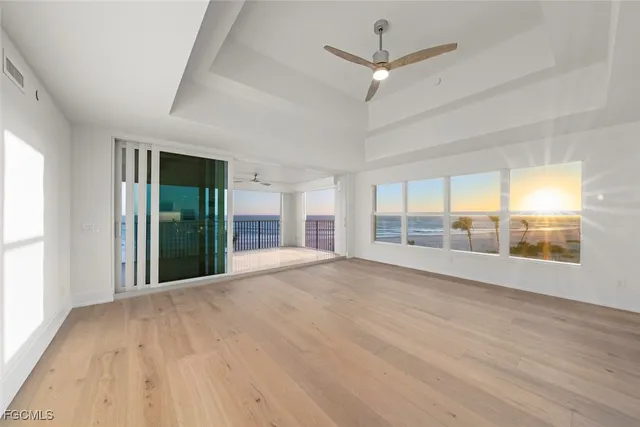 a view of an empty room with a window and a kitchen view