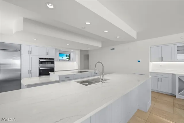 a kitchen with stainless steel appliances granite countertop a sink and white cabinets