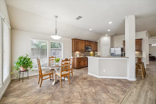 a dining room and kitchen with a table chairs and a living room