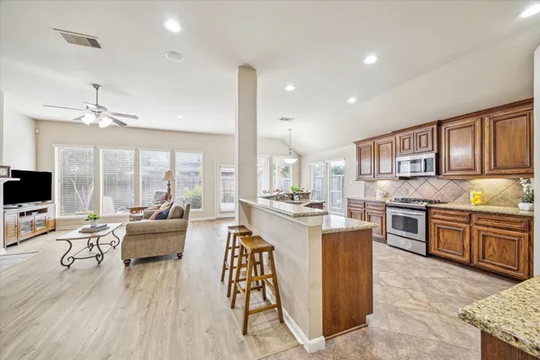 a large kitchen with kitchen island granite countertop a large center island and a stove in it