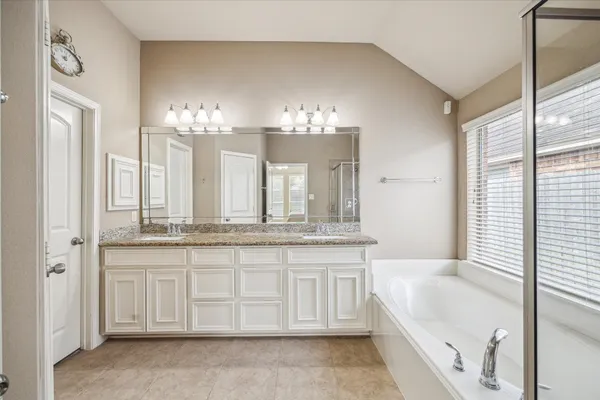 a bathroom with a tub sink and mirror