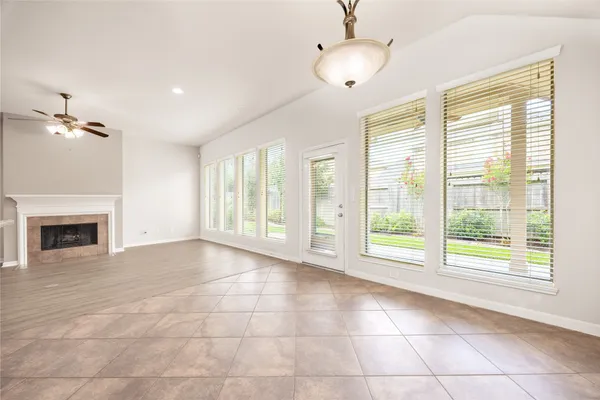 a view of an empty room with a fireplace and a window