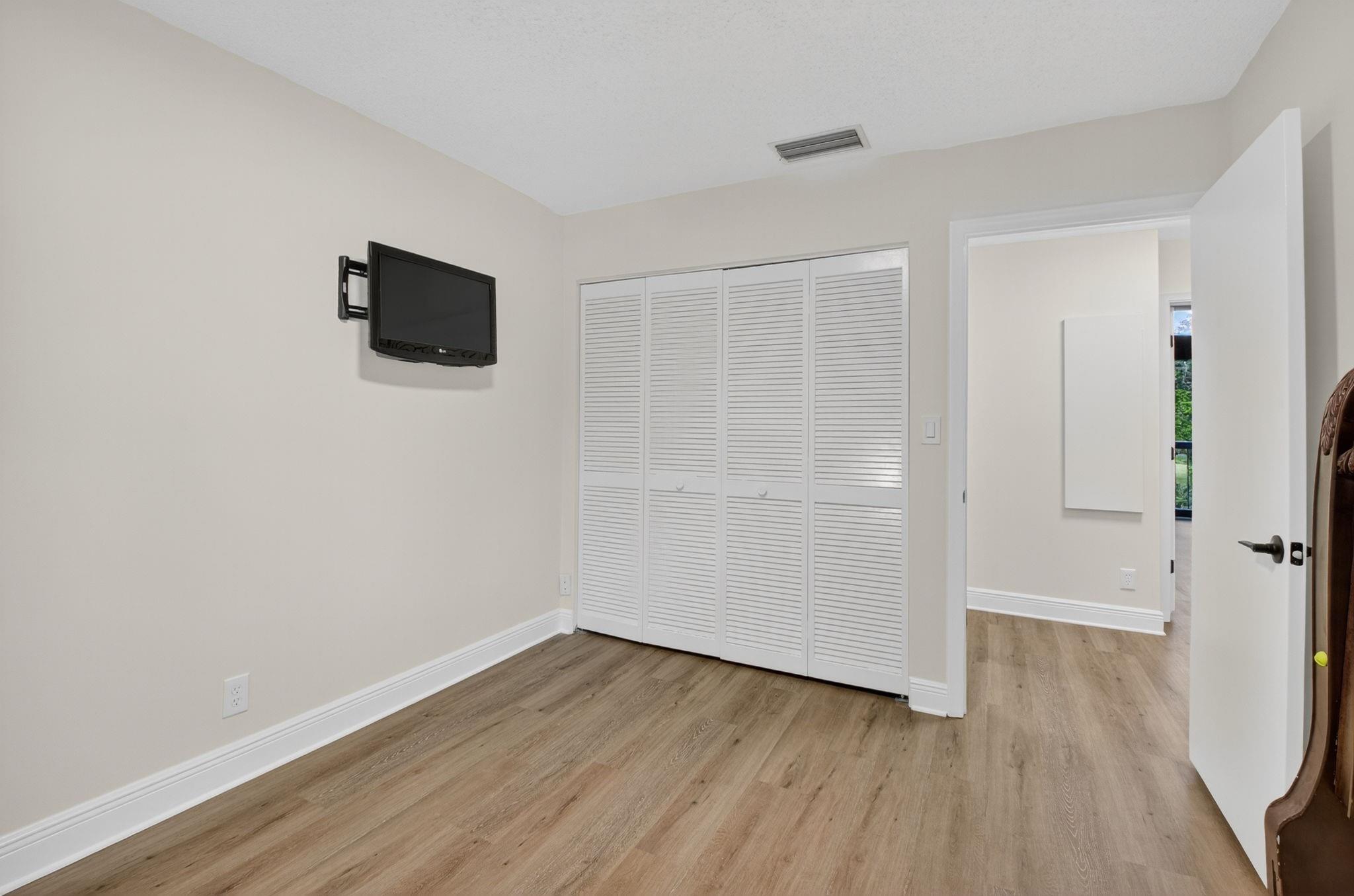 3802 Bridgewood Drive Boca Raton, FL 33434 - Photo 26 of 46 a view of a room with wooden floor and a flat screen tv