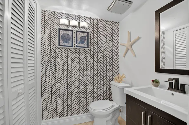 a bathroom with a sink a toilet and mirror