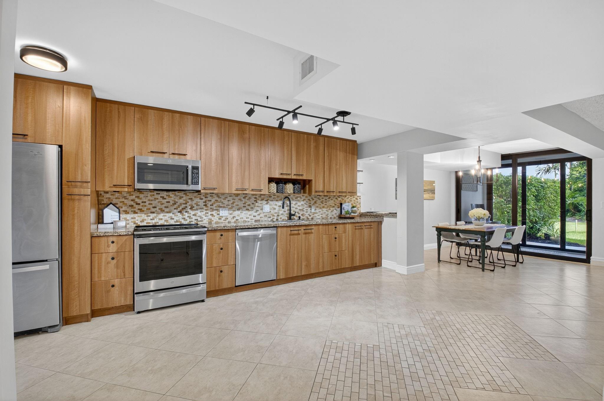 3802 Bridgewood Drive Boca Raton, FL 33434 - Photo 8 of 46 a kitchen with a stove a sink and a refrigerator