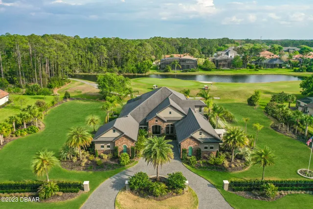 an aerial view of a house with a garden and lake view