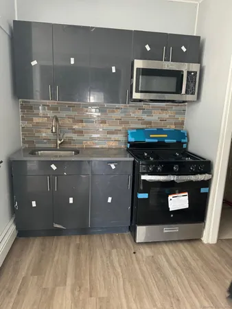 a kitchen with stainless steel appliances granite countertop a stove a microwave and a sink