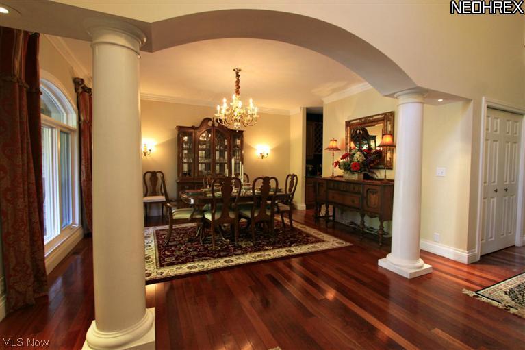 The Formal Dining Room is open to the foyer on the left through ths wide lighted archway with round stately pillars. A large arched window wall overlooks the open front porch and beautifully landscaped front yard.