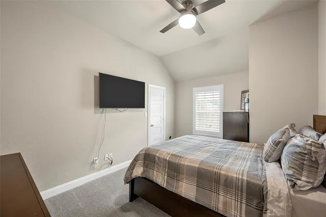 a bedroom with a bed tv and a window