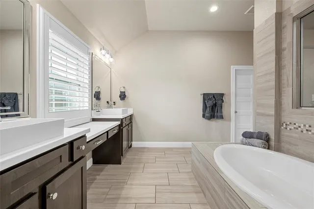 a bathroom with a tub sink and mirror