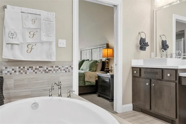 a en suite bathroom with a tub sink and mirror