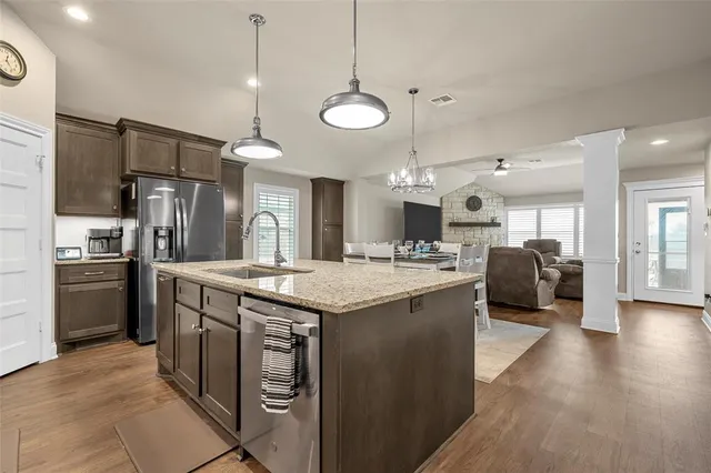 a kitchen with stainless steel appliances granite countertop a sink a stove and a refrigerator
