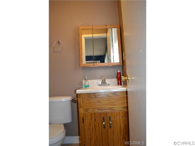 15804 Tri Gate Road Chester, VA 23831 - Photo 10 of 13 a bathroom with a toilet sink vanity and mirror