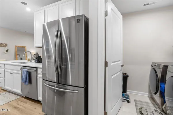 a view of a refrigerator in kitchen and utility room