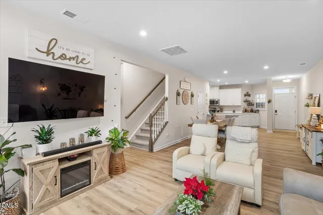 a living room with furniture a flat screen tv and a potted plant