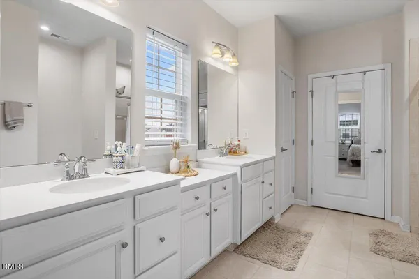 a spacious bathroom with double sink and a mirror