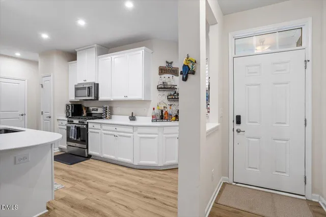 a kitchen with white cabinets and stainless steel appliances