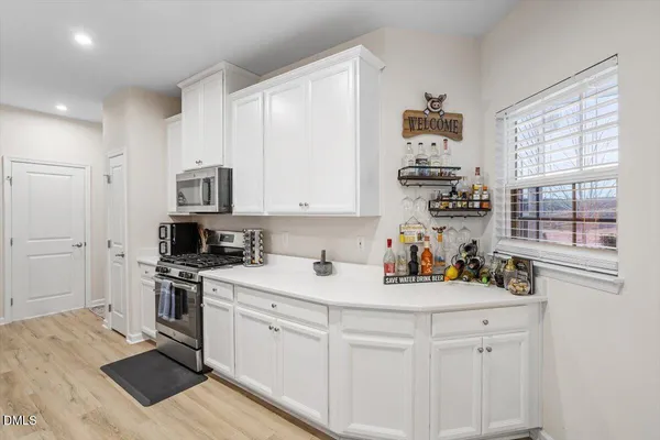 a kitchen with white cabinets and appliances
