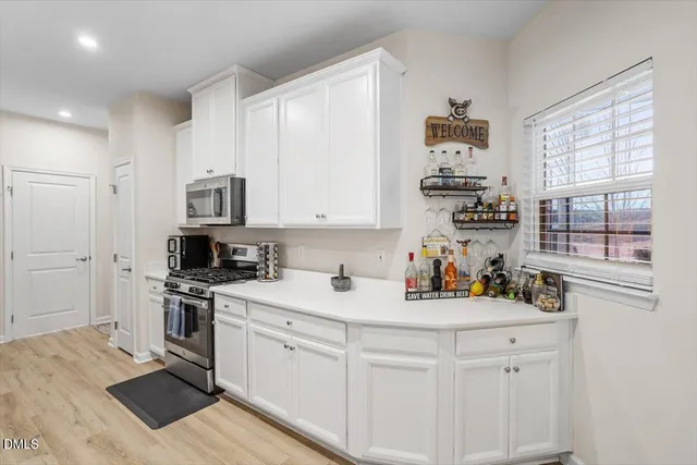 a kitchen with white cabinets and appliances