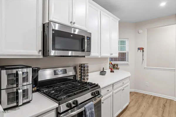a kitchen with stainless steel appliances a stove a microwave and cabinets