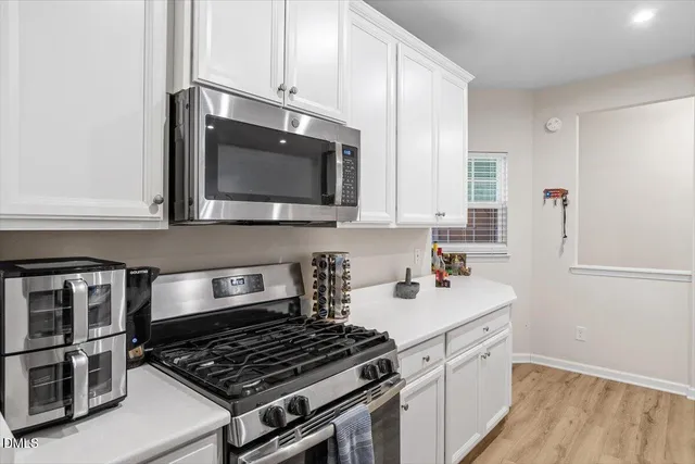 a kitchen with stainless steel appliances a stove a microwave and cabinets