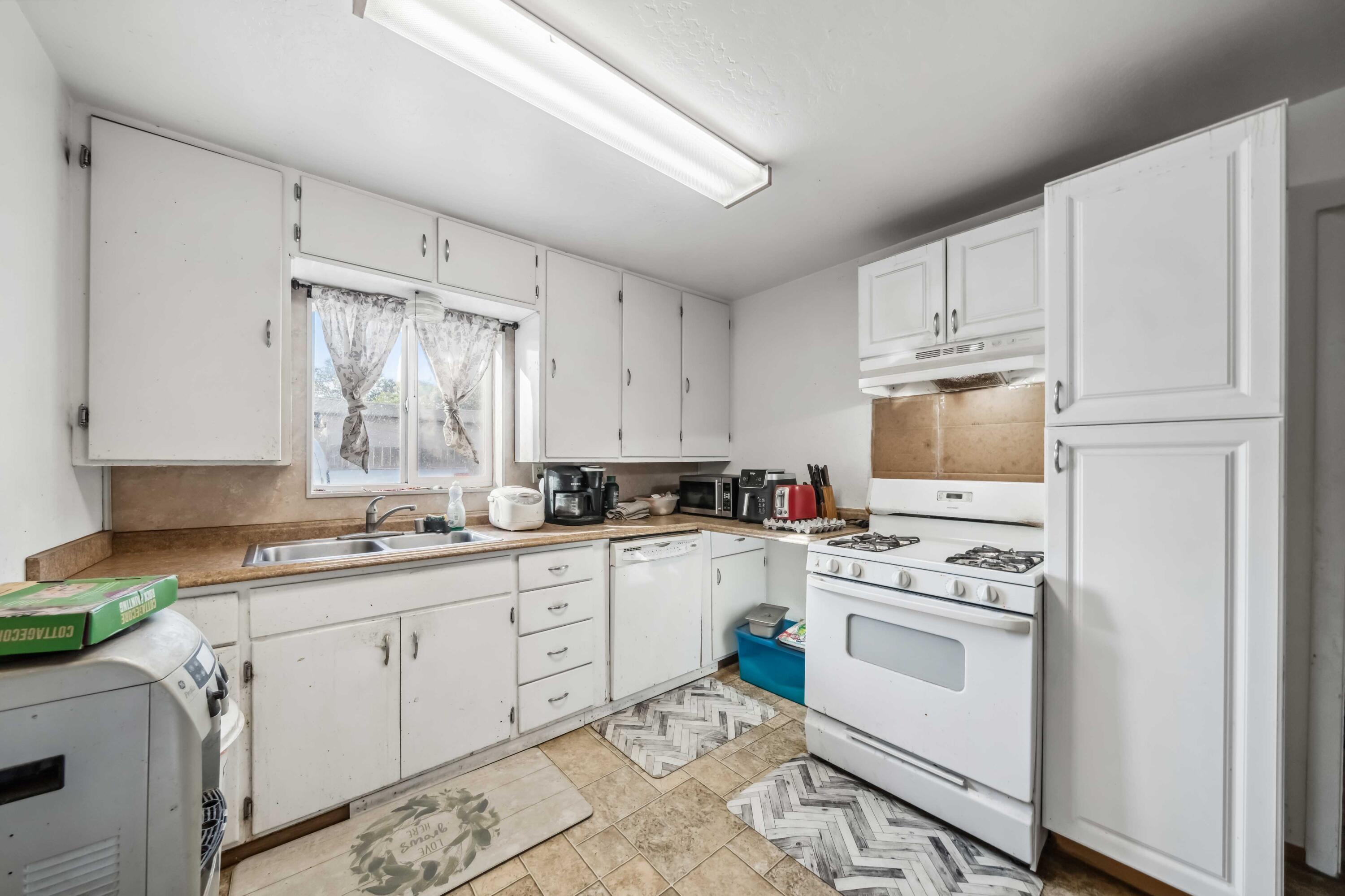 5450 Cedars Road Redding, CA 96001 - Photo 7 of 21 a kitchen with white cabinets sink and white appliances