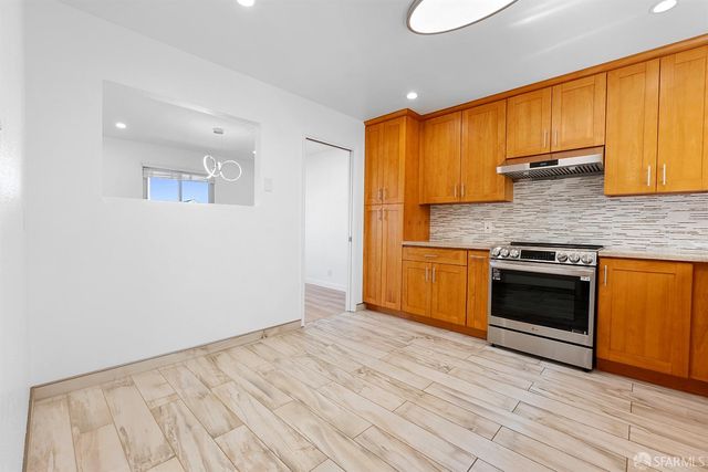 a kitchen with granite countertop wooden floors and stainless steel appliances