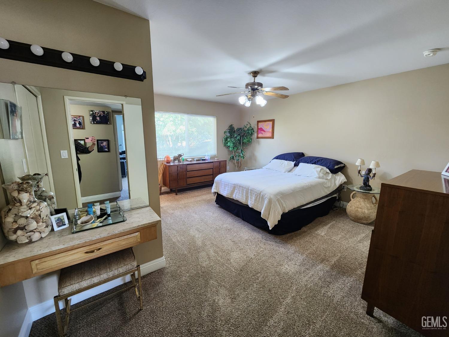 Undisclosed Address Bakersfield, CA 93309 - Photo 8 of 22 a spacious bedroom with a bed and a chandelier