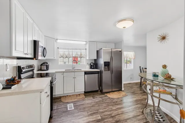 a kitchen with a refrigerator cabinets and wooden floor