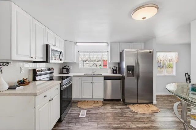 a kitchen with a refrigerator sink and cabinets