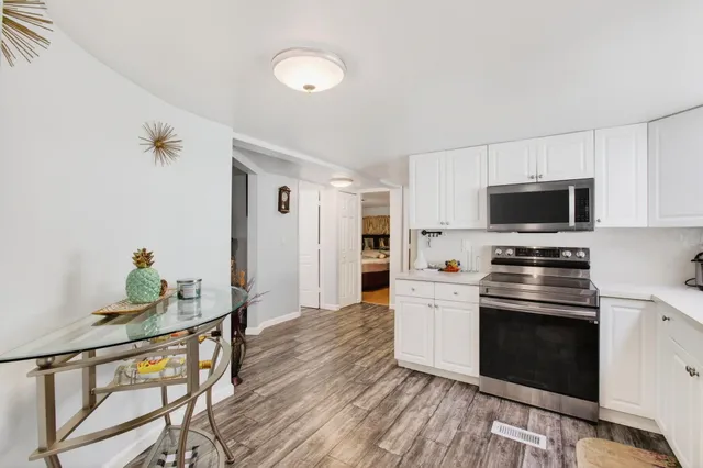 a kitchen with granite countertop a stove and a wooden floor